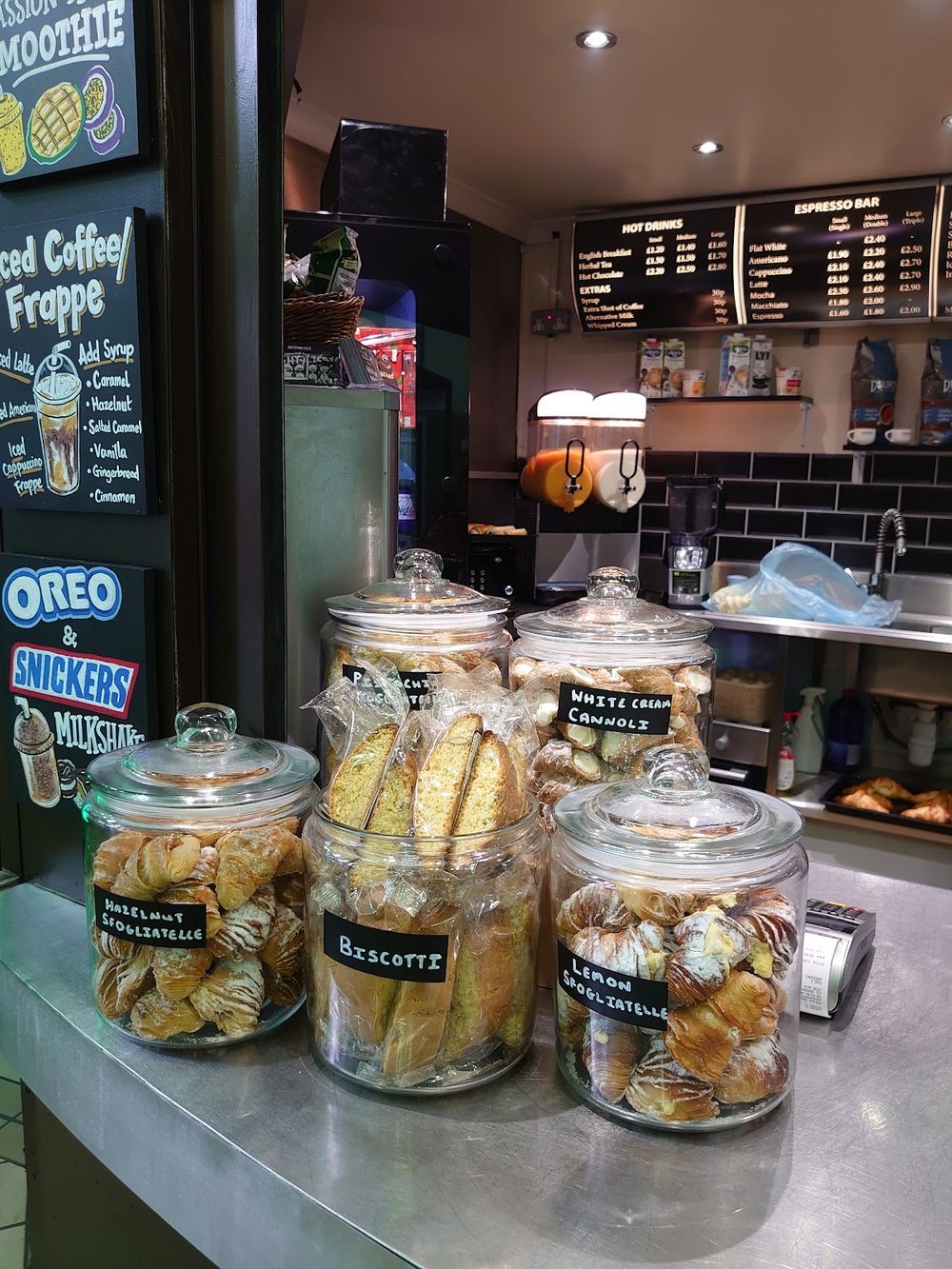 The service counter, with glass jars of biscotti and cookies in front of the coffee machine.